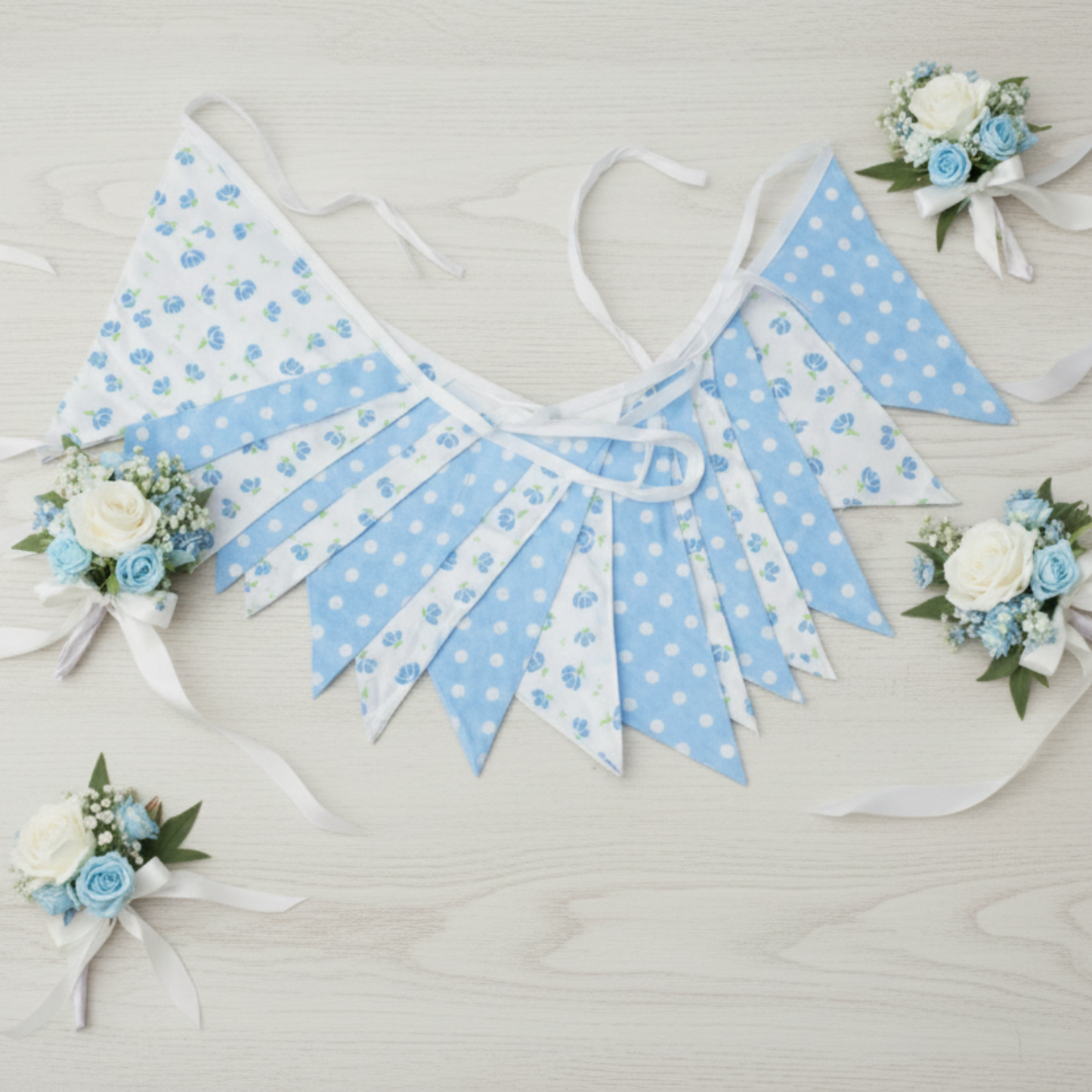 Blue and white polka dot bunting with floral decorations on a wooden surface