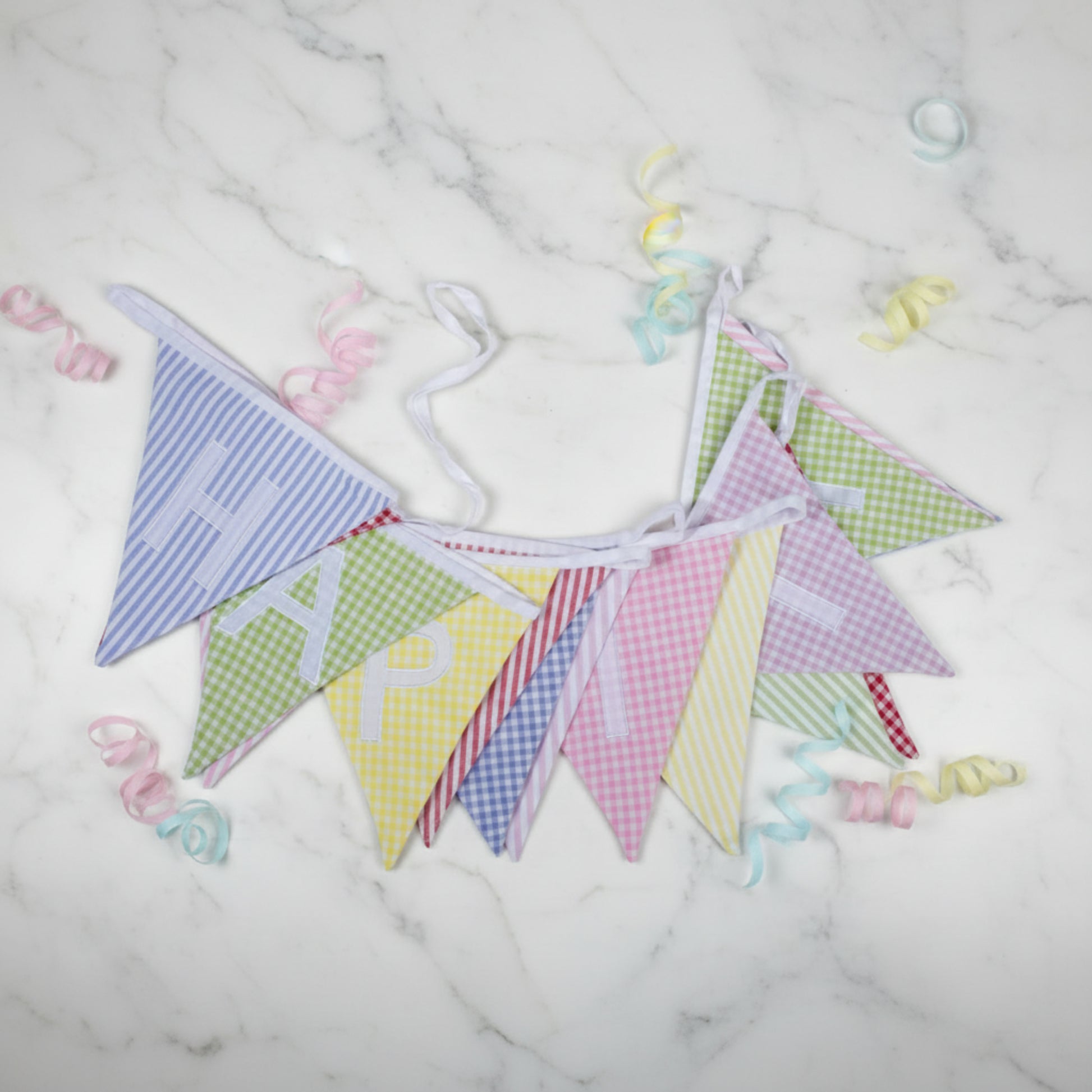 Colourful checkered bunting with happy birthday letters on a white background