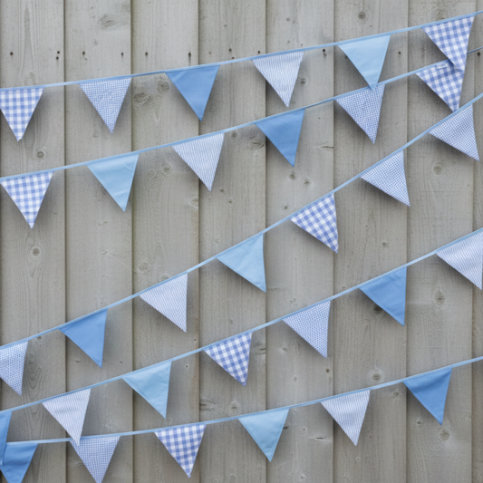 String of blue and gray checkered and solid triangle flags against a wooden background